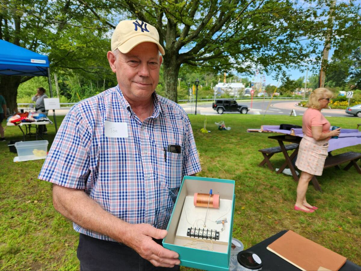 Tom R. Sulier holds a foxhole radio, an old technology once used by soldiers at war.