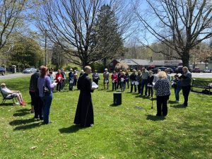 Father Joseph Gill of St. Jude Parish leads a prayer on Stepney Green Thursday afternoon.